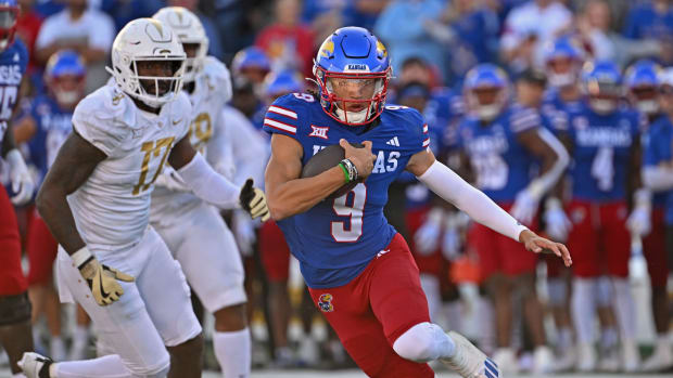 Oct 7, 2023; Lawrence, Kansas, USA; Kansas Jayhawks quarterback Jason Bean (9) runs up field for a first down against the UCF Knights during the second half at David Booth Kansas Memorial Stadium. Mandatory Credit: Peter Aiken-USA TODAY Sports  